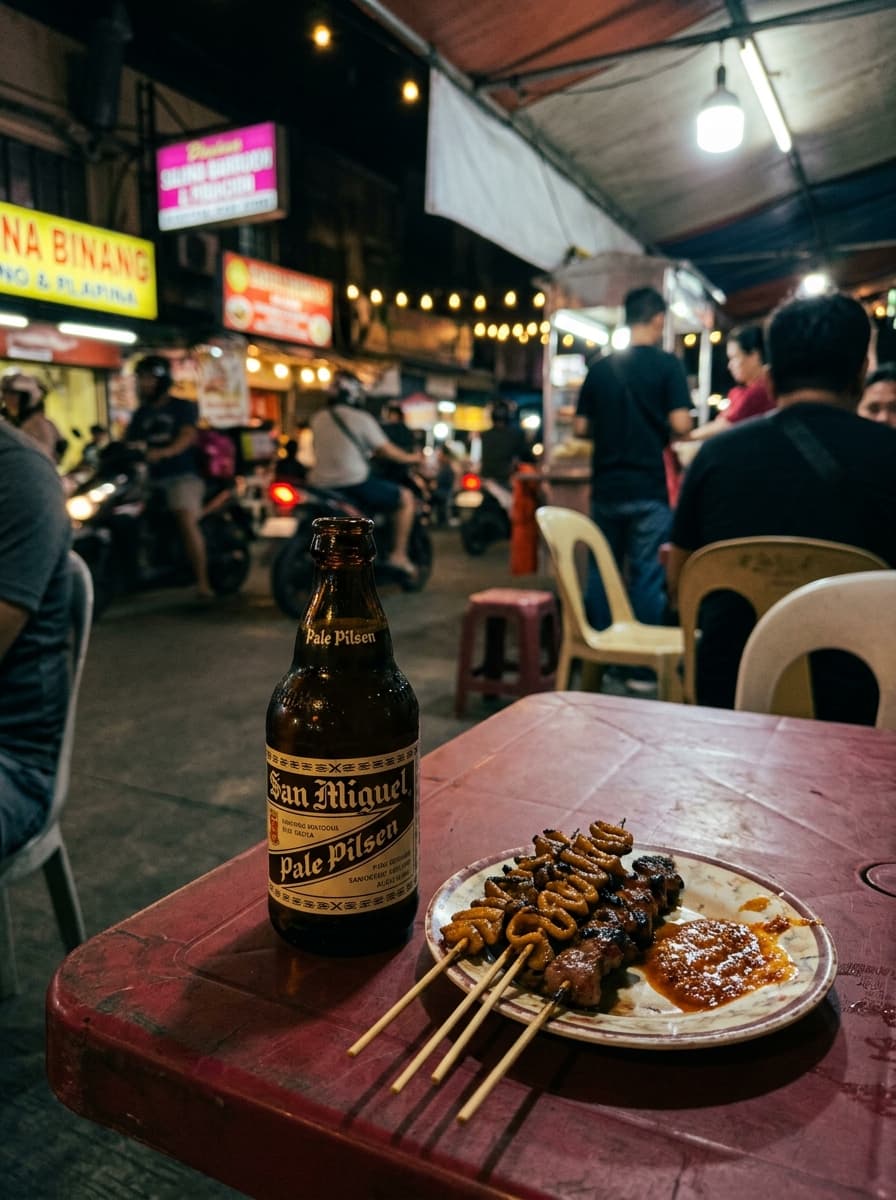 San Miguel beer bottle on a plastic table with street food in background